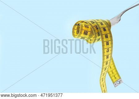 Fork With Measuring Tape On Light Blue Background, Space For Text. Diet Concept