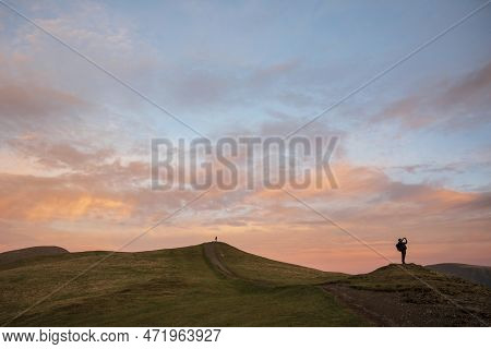 Beautiful Winter Sunset Landscape Over Latrigg Fell In Lake District With Two People On Hilltop Admi