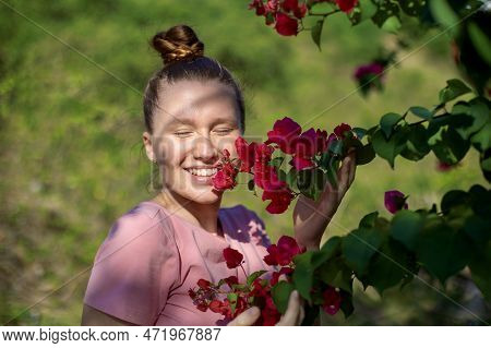 Portrait Of Happy Beautiful Girl, Young Positive Woman Is Smelling Beautiful Yellow Flowers In The G