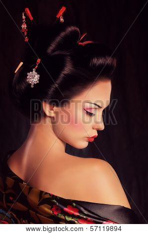 Beautiful geisha in kimono with samurai sword