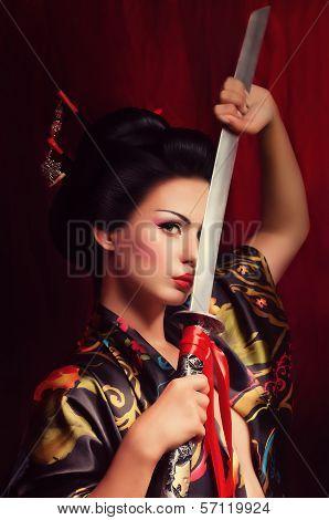 Beautiful geisha in kimono with samurai sword