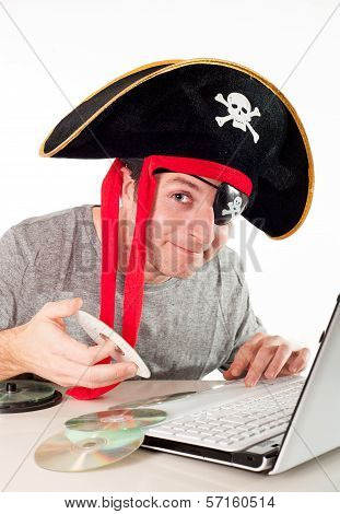 Man In Pirate Hat Downloading Music On A Laptop