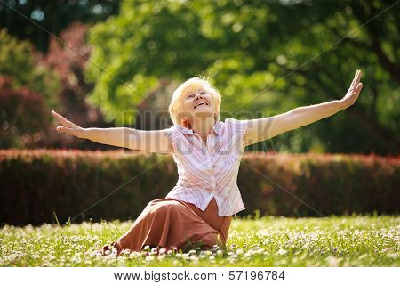 Gladness. Meditation. Mature Pleased Woman Relaxing With Outspread Arms