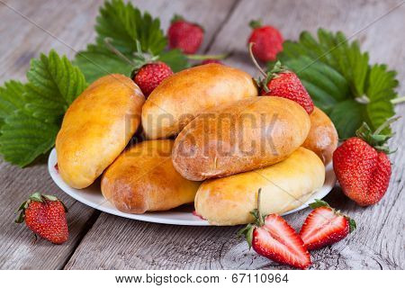 Fresh baked pasties with strawberries on plate close-up
