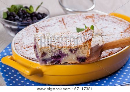 Semolina cake with berries, slice on a wooden spatula