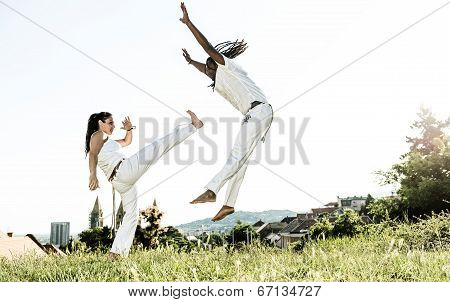 Pair of capoeira performers doing a kicking