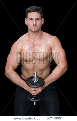Strong crossfitter lifting up heavy black dumbbell on black background