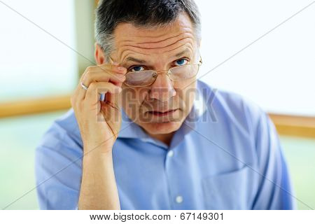 Senior man in glasses looking at camera