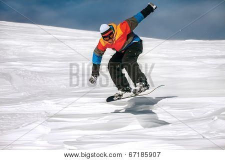 Snowboarder jumping through air with deep blue sky in background