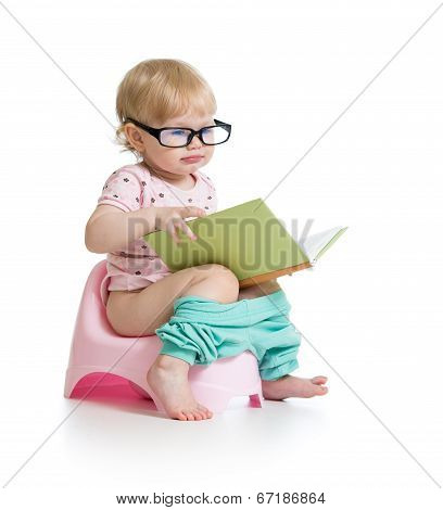 Baby Girl Sitting On Chamberpot With Book
