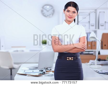 Attractive businesswoman with her arms crossed  standing in office