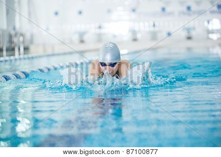 Young girl in goggles swimming breaststroke stroke style