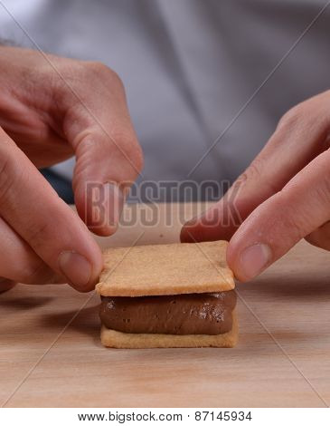Cook preparing nuts cream cookies.