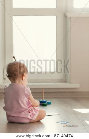 Little Girl Playing With Pyramid On Floor