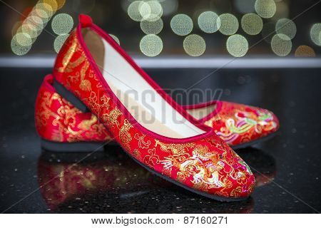 A traditional pair of red wedding shoes.