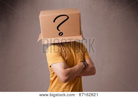 Young man standing and gesturing with a cardboard box on his head with question mark