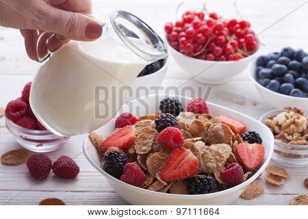Breakfast - berries, fruit and muesli on white wooden