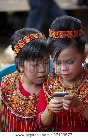 Portrait Of Two Young Torajan Girls with mobile phone