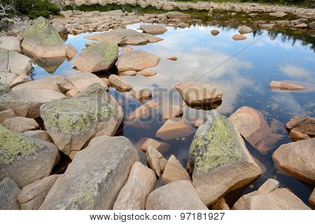 Stones In Lake In Mountains.