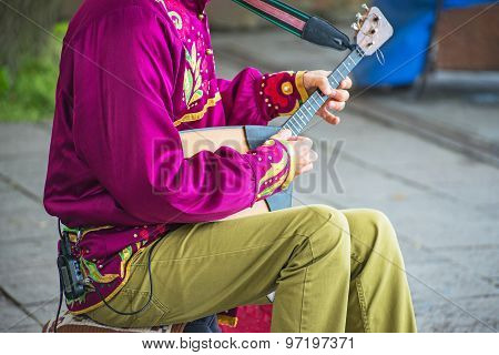 Man Playing Balalaika On The Street. Unrecognizable Person.