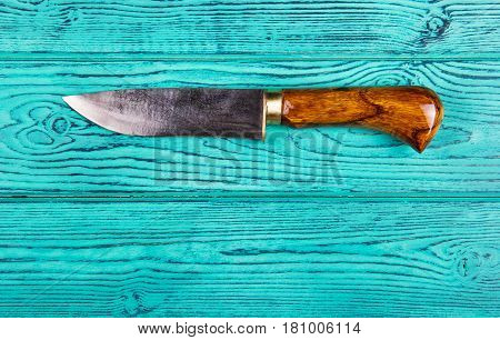 Kitchen hand knife with a handle made of natural wood brass and steel. Knife for men. A beautiful knife on an old wooden background. Top view. Copy space