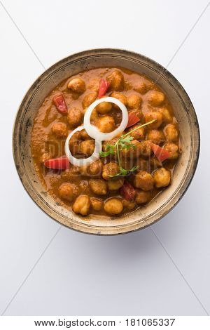 spicy chick peas curry or Chola Masala or Chana Masala or chole bhature or choley garnished with sliced onion and green coriander leaf, selective focus