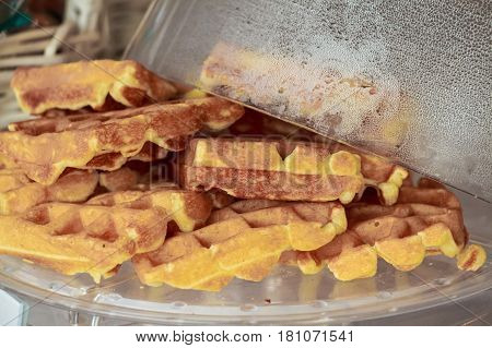 Closeup image of freshly cooked Belgian waffles lying on plate