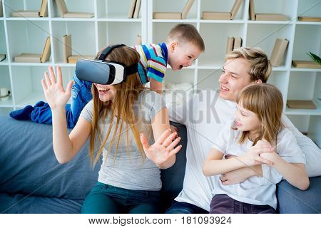 Happy family at home and playing with virtual reality goggles, VR headset, modern technology glasses