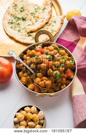 spicy chick peas curry or Chola Masala or Chana Masala or chole bhature or choley garnished with sliced onion and green coriander leaf, selective focus