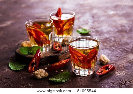Transparent alcoholic drink with red pepper. Selective focus.