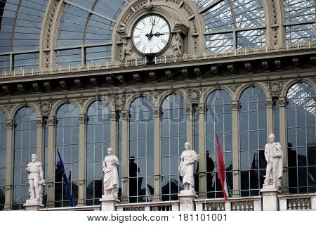 Close-up of Keleti railway station facade with watch and antique sculptures above central entrance. Terminal located in Budapest, Hungary