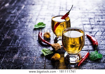Transparent alcoholic drink with red pepper. Selective focus.