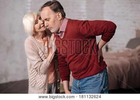 It will be gone. Portrait of elderly man leaning while having strong backache and his wife supporting him.
