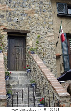 VAL'QUIRICO, TLAXCALA, MEXICO-MARCH 25, 2017: Facade of a building with stone walls and an ancient door at a street in Val'Quirico, a new town near to Tlaxcala, Mexico