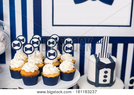 Cake, candies, marshmallows, cakepops, chocolate and other sweets on dessert table at kids birthday party. Birthday Dessert celebration candy bar in white and blue colors.