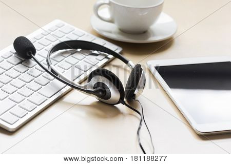 profession concept with aup and headset of call center manager on beige desk background