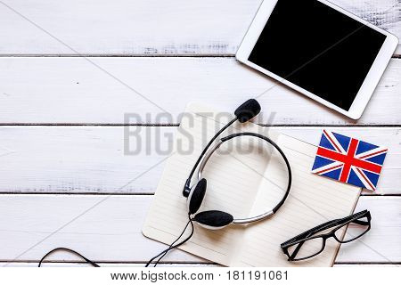 lifestyle learning english online with flags and tablet on white wooden table background top view mockup