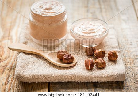 organic cosmetic for women body care with natural huzelnut scrub on desk background