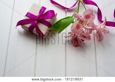 spring flowers and a gift on a wooden table