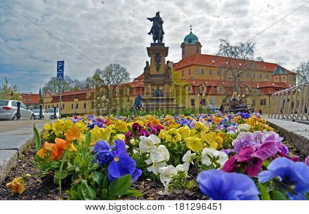 Closeup view on flowerbed on central square of Czech spa city Podebrady, which is dominated statue of George of Podiebrad, was King of Bohemia, and castle