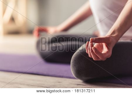 Cropped image of beautiful pregnant woman meditating while doing yoga