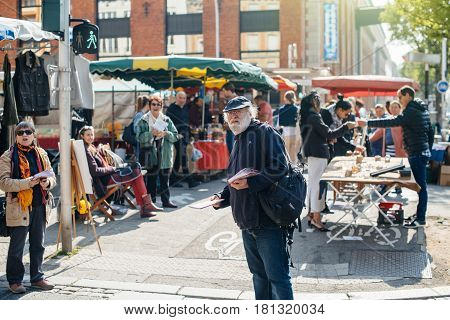 STRASBOURG FRANCE - APR 8 2017: Political agitation at French market for the upcoming French presidential election 2017 - senior French man distribution political information at market