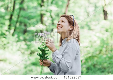 Young woman picking flowers outside in nature