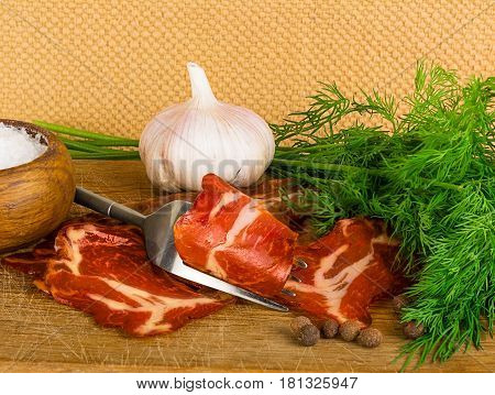Country still life with bacon with pepper on wooden plate