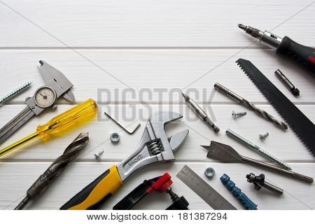 Construction tools lie on a wooden white background