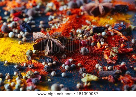 Cardamom anise. Different colorful seasonings close-up against a black chalk board