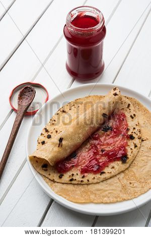 indian bread or chapati or paratha rolled with fruit jam, typical tiffin menu for indian school kids, selective focus