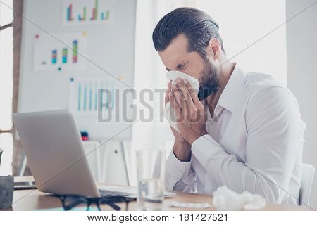 Sick Businessman With Temperature Works In Office And Wipes His Nose With A Napkin