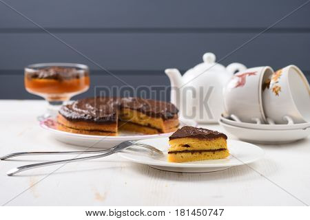 Tea table with teaware low callorie pumpkin dessert and homemade layered pumpkin cake with chocolate ganache closeup
