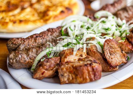 Traditional Georgian Mtsvadi Pork Barbecue And Kebab With Onion And Parsley